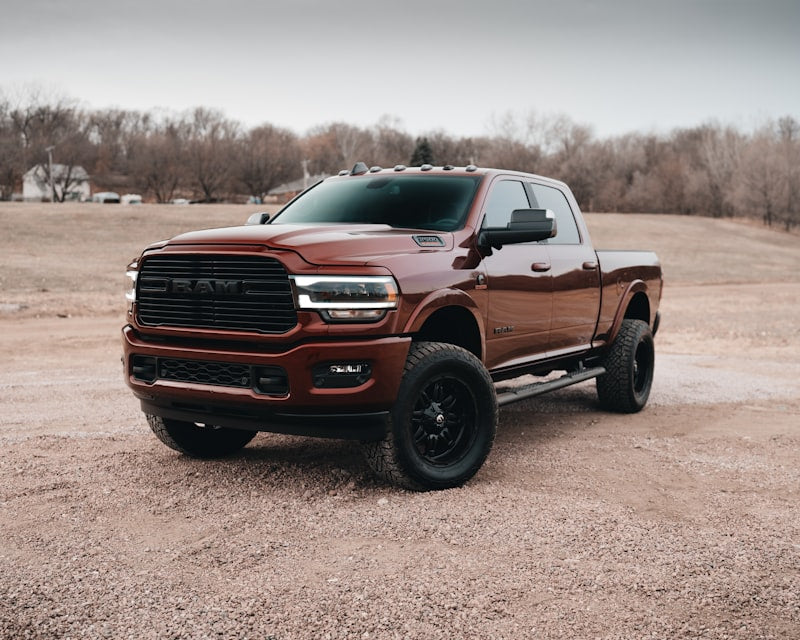 Red Chevy crew cab pickup truck on dirt road showing truck bed